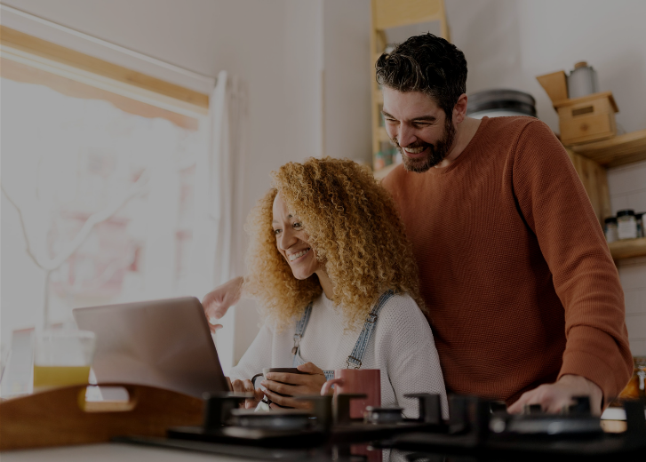 couple smiling at laptop